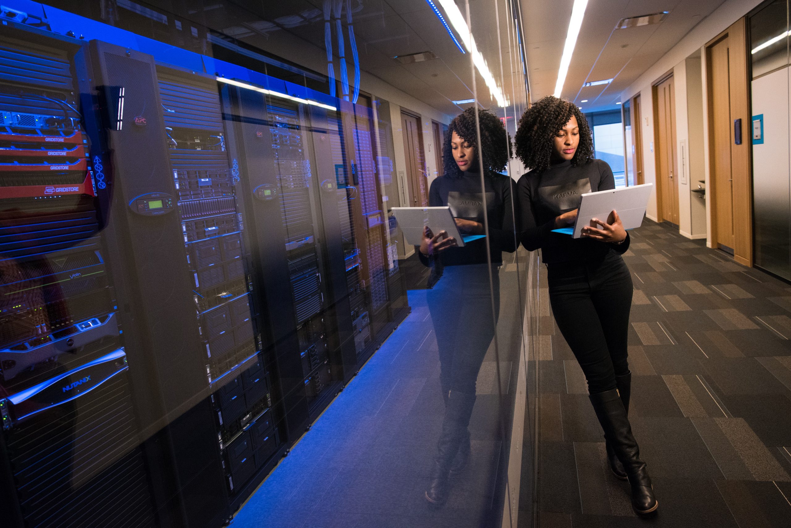 Woman standing in front of server on a laptop